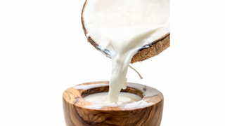 Coconut milk being poured into coconut bowl